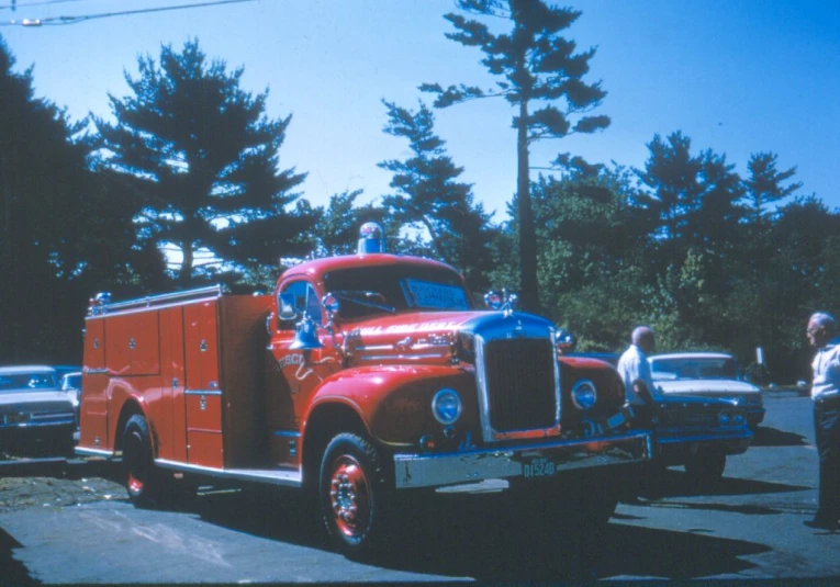 a man that is looking at a red truck