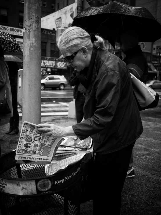 an elderly man is reading the paper outside