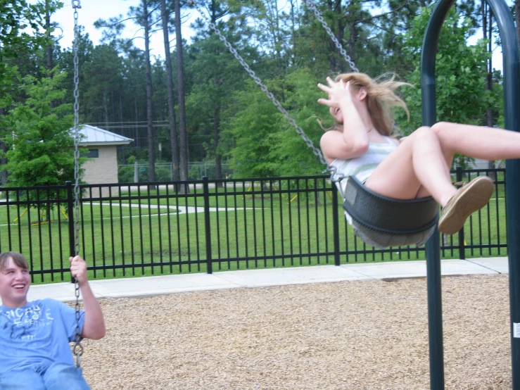 two people at a park on swings and smiling