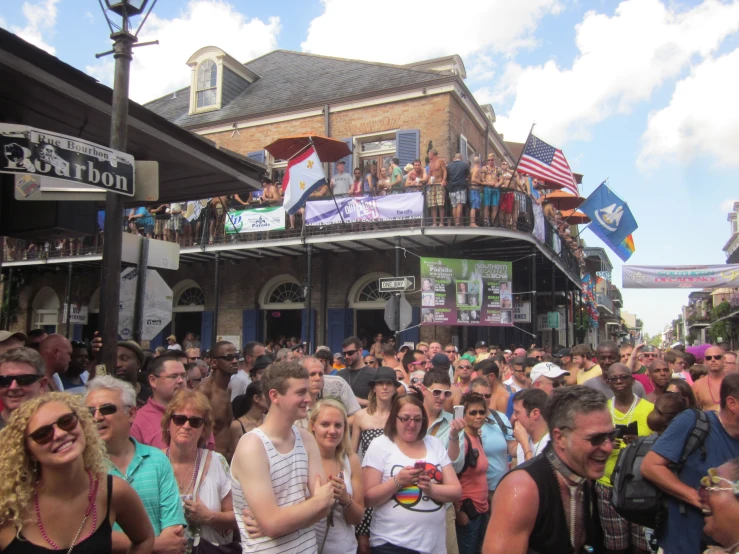 many people stand around a street with a building in the background