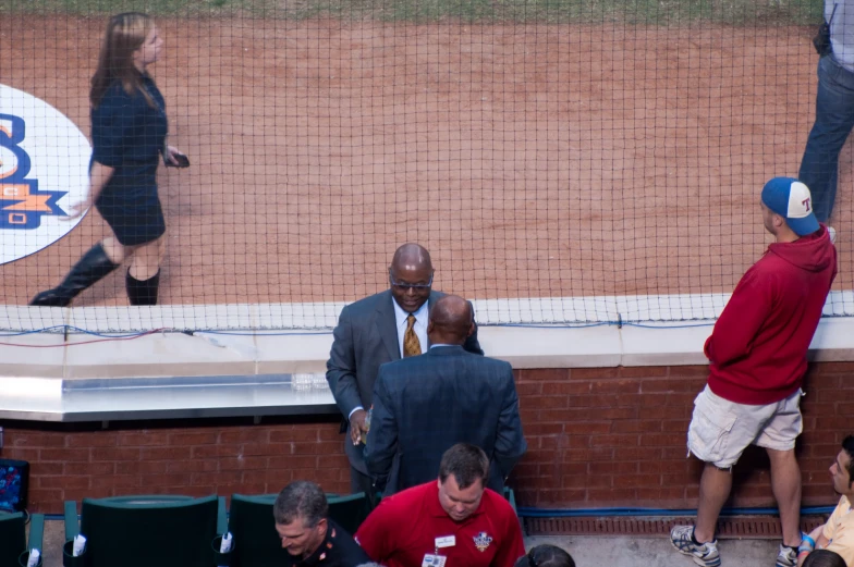 some people are standing around a baseball field