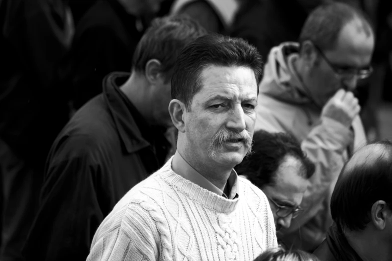 a man wearing a shirt and tie standing in front of a crowd