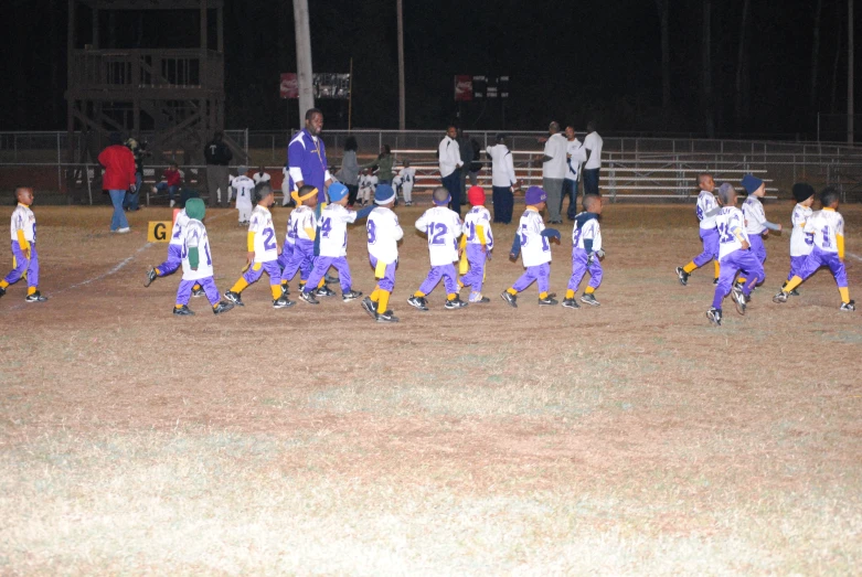 teams of young children playing soccer in a field