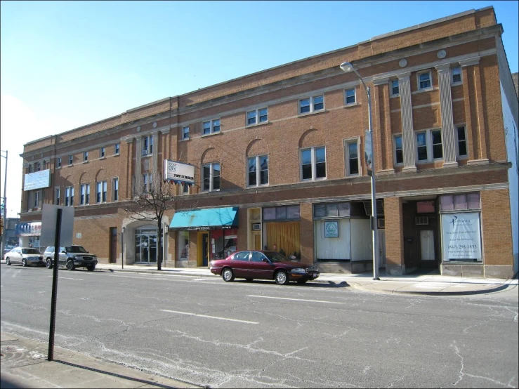 an old brick building with parked cars in front
