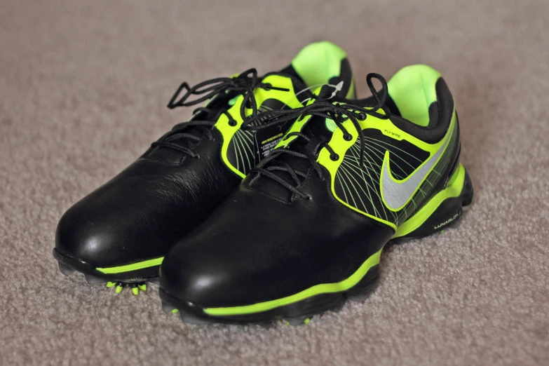 a pair of black, yellow and green shoes are laying on the floor