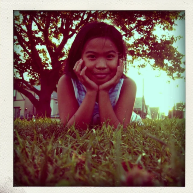 an adorable little girl laying in the grass