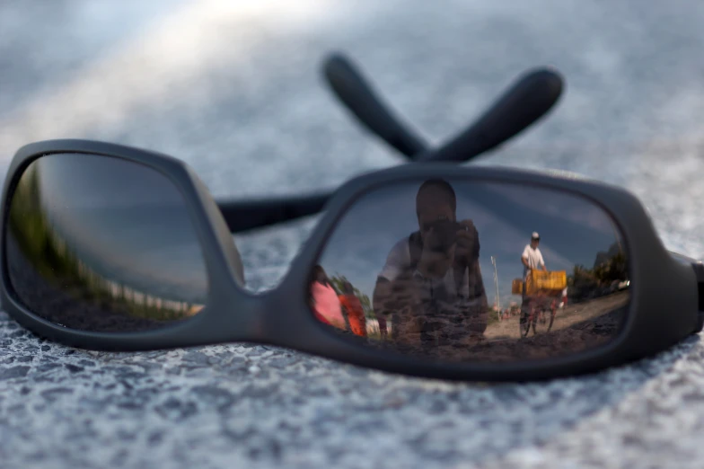 the reflection of people riding horses behind a pair of sunglasses