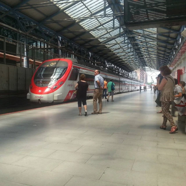 a train on tracks next to people standing