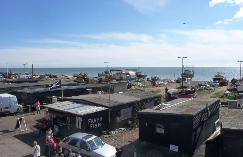 an aerial view of some black shacks and vehicles