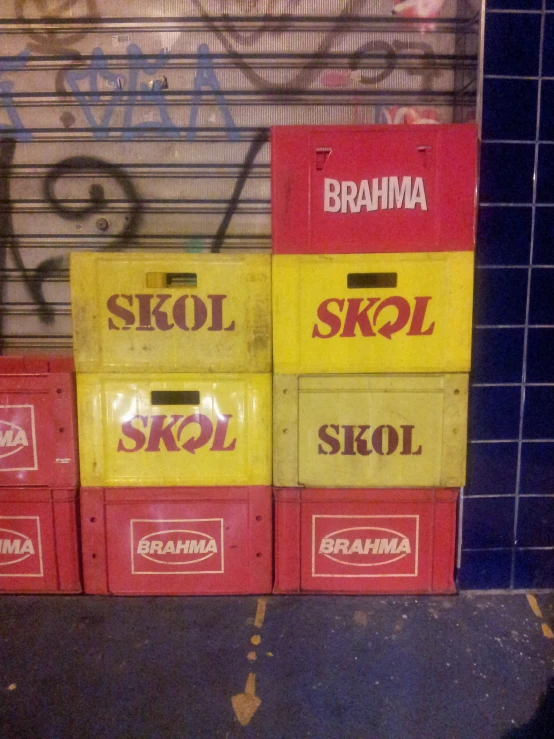 several boxes of skol next to graffiti on the wall