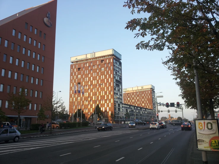 a city street that has cars in front and two large buildings on both sides