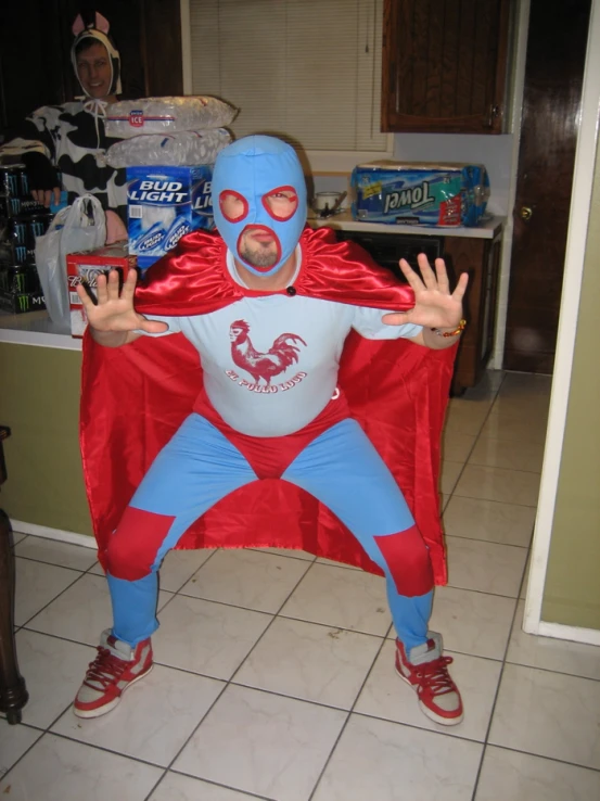 a man wearing a red and blue costume is standing in the middle of a kitchen