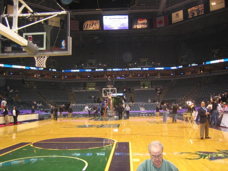 an old man in a basketball court sitting on a ball