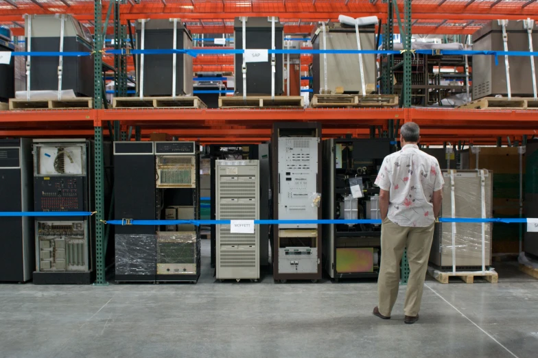 a man that is looking at electronics in a room