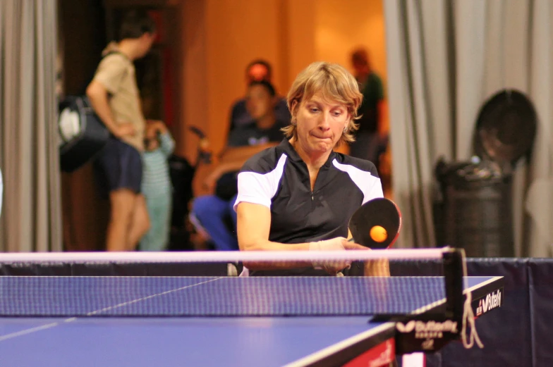 a man holding a ping pong paddle while playing tennis