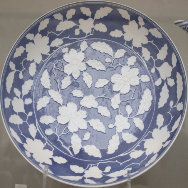 a blue and white plate with leaves on it