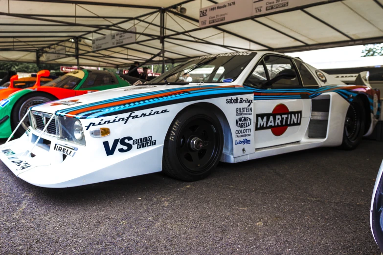 two porsche sports cars side by side under a tent