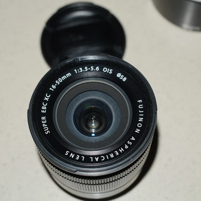 a black camera lens laying flat on a white table