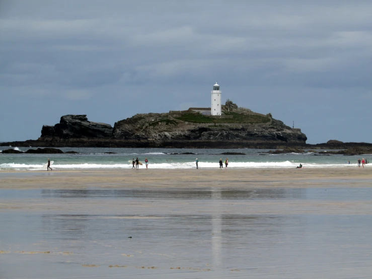 many people at the edge of a large ocean beach