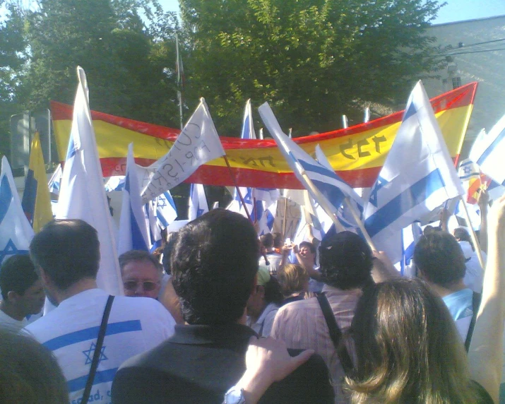 a group of people holding flags in different colors