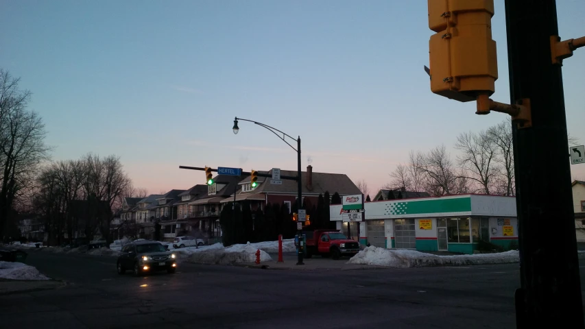 some cars are stopped at the corner of a road