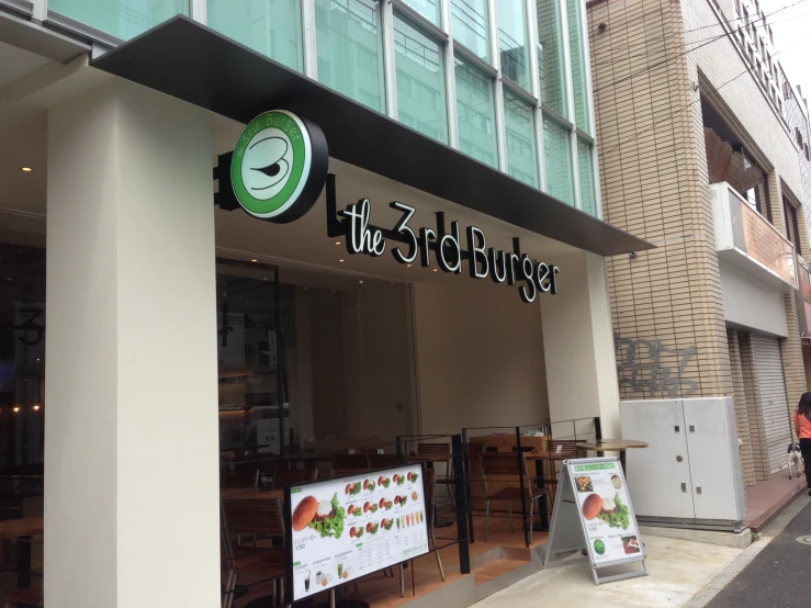 a restaurant front on the street with a person passing by