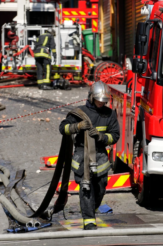 a firefighter with the hose he's currently using is doing soing