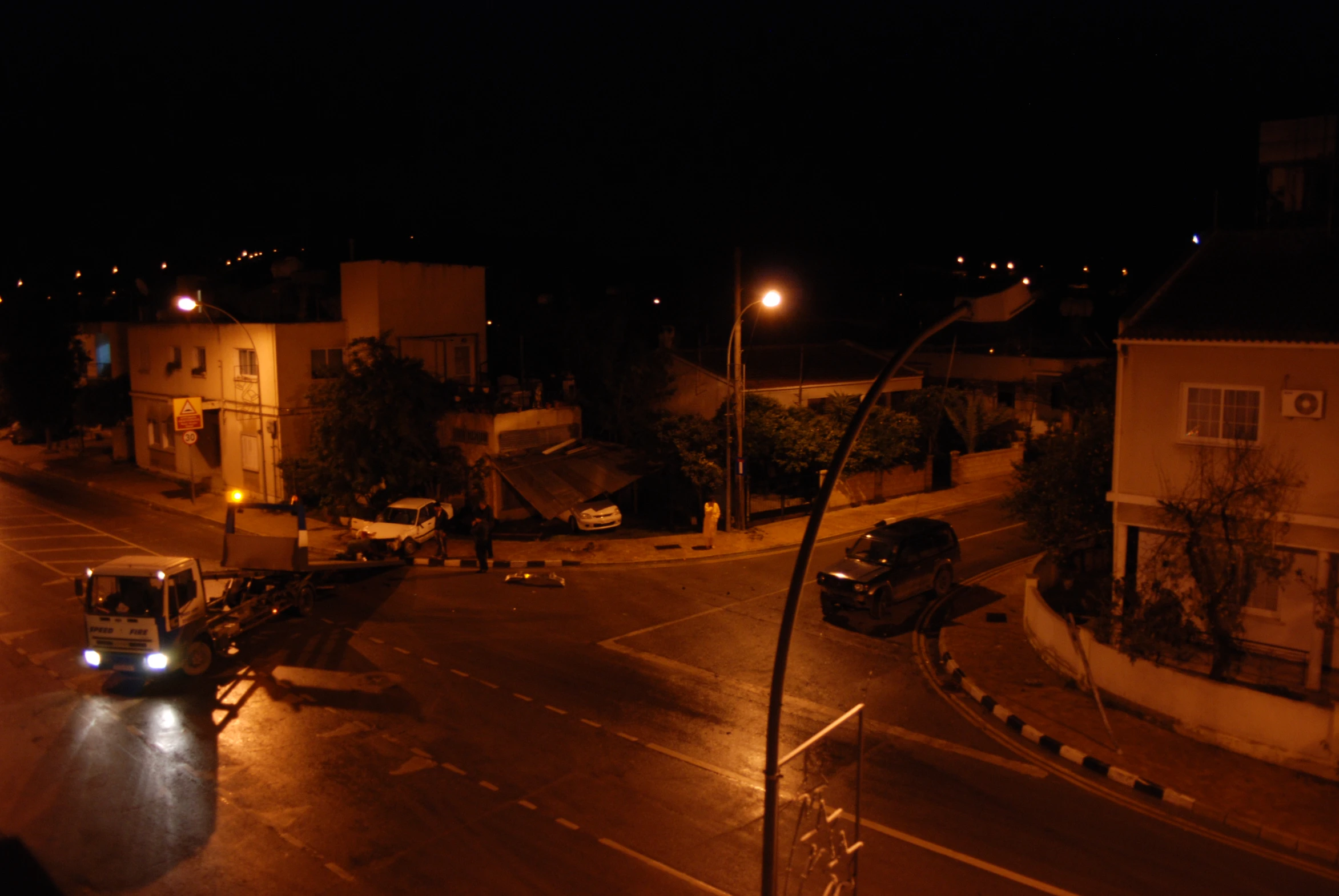 vehicles are parked at the intersection of an empty street