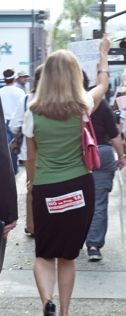 a woman wearing black pants walking along the street