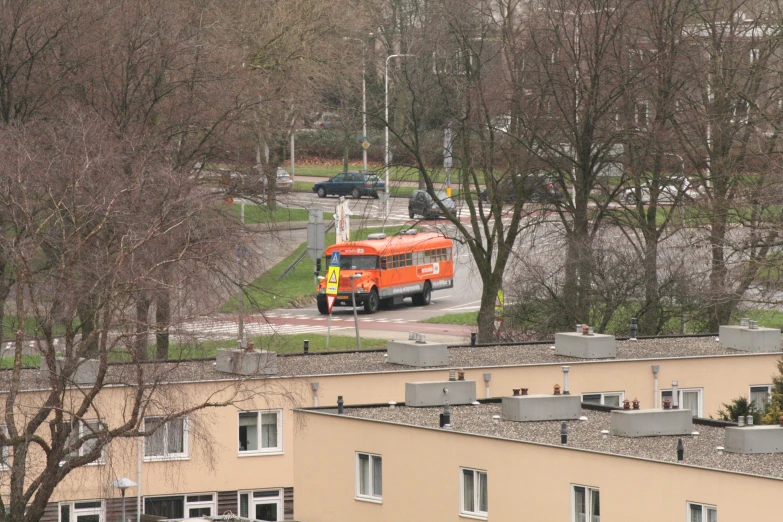 a red and yellow bus sitting in front of some buildings