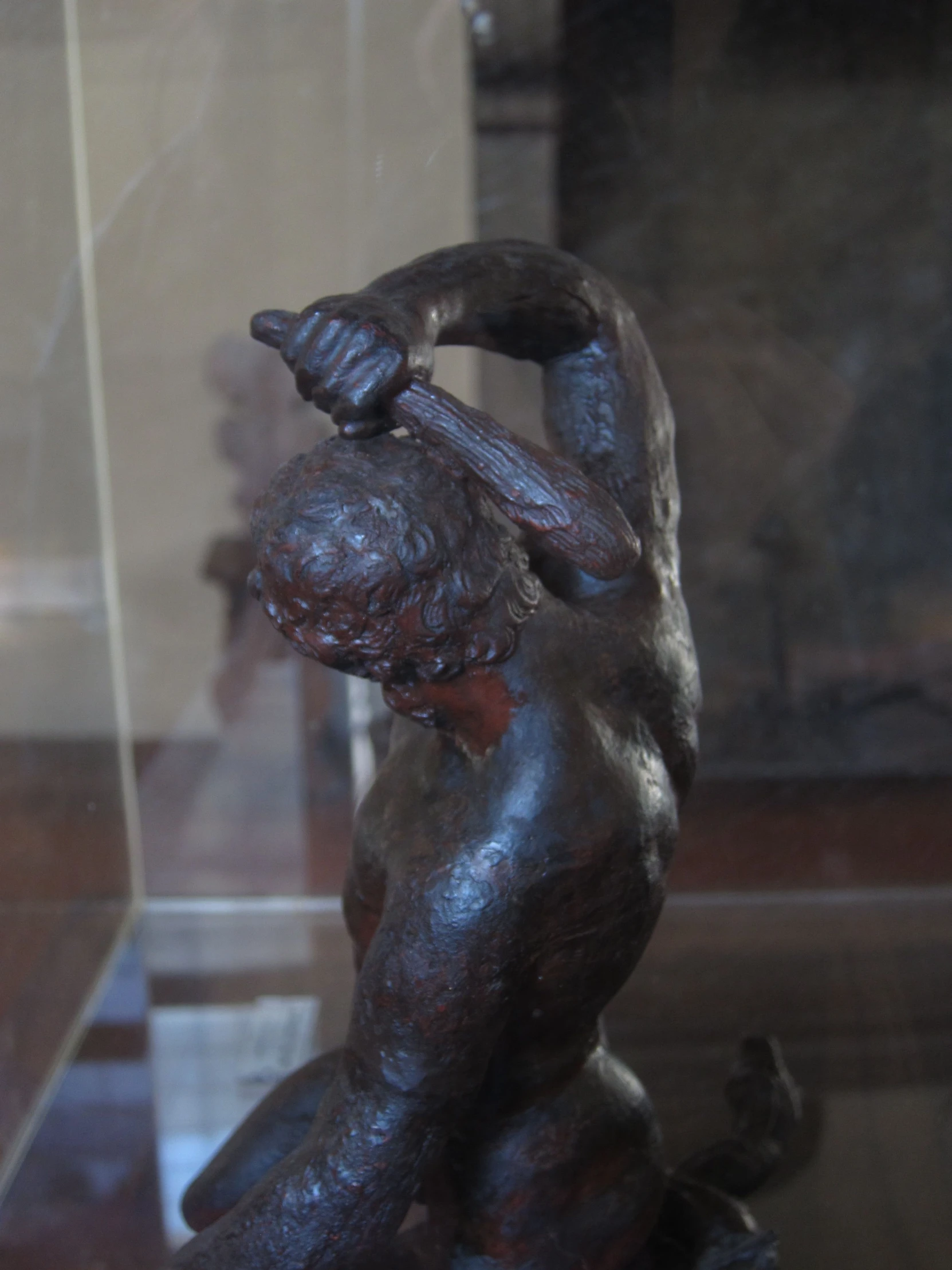 an old and worn bronze statue of a boy