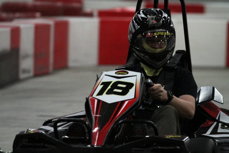 a man riding on top of a cart around a track