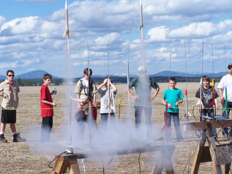 group of people in a field behind a grill