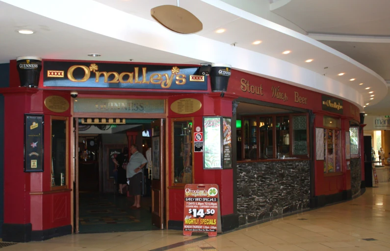 an entrance to a large restaurant with signs advertising its own bar