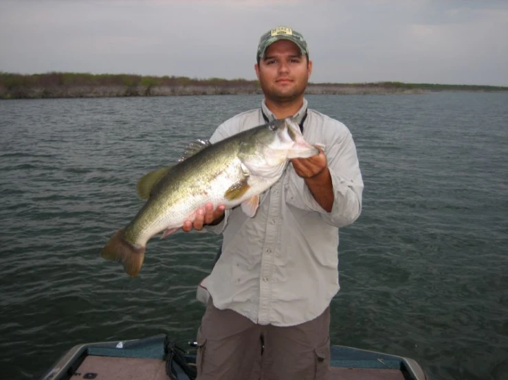 a man in a boat holding up a large fish