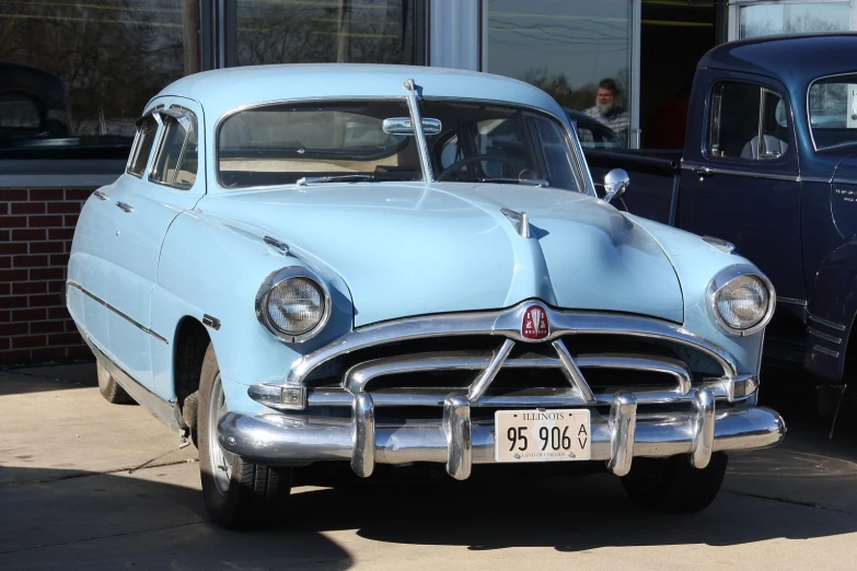 an old classic car is parked in front of a building