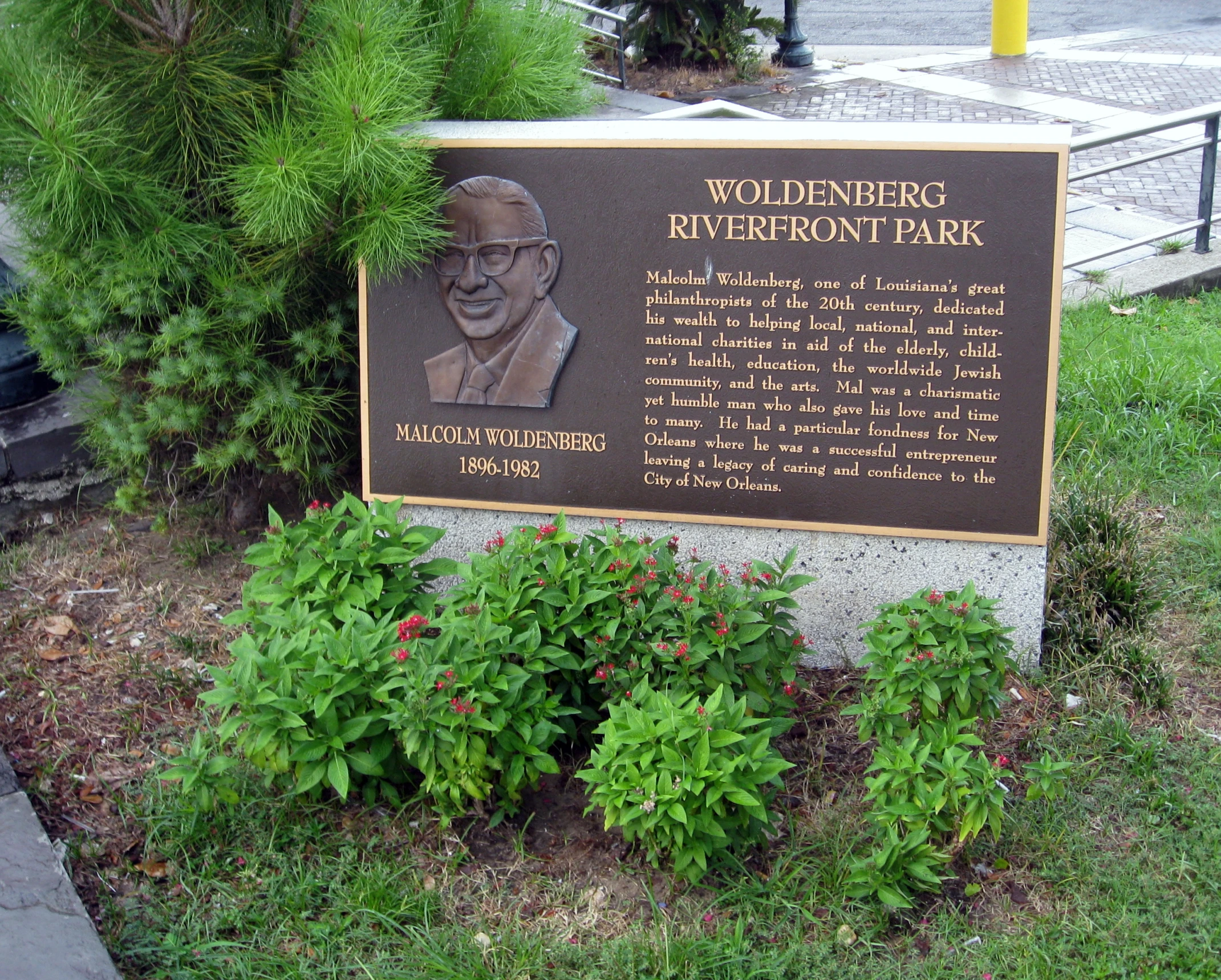 sign in front of a flower bed describing an exhibit