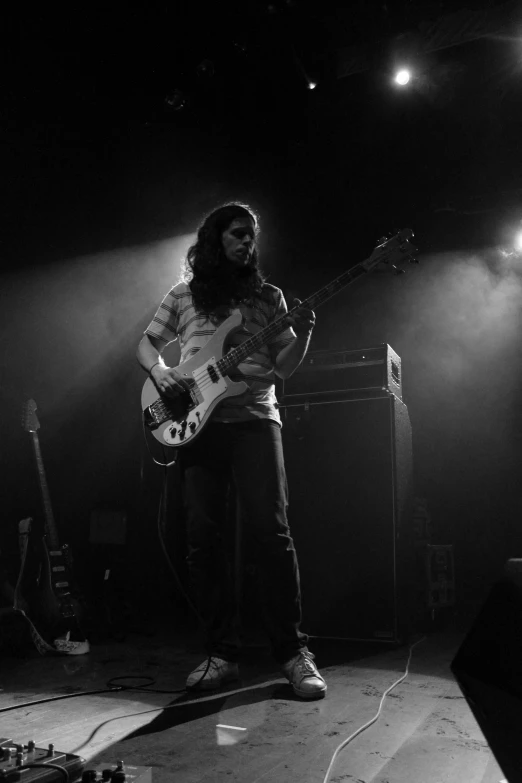 a man standing on stage playing a guitar