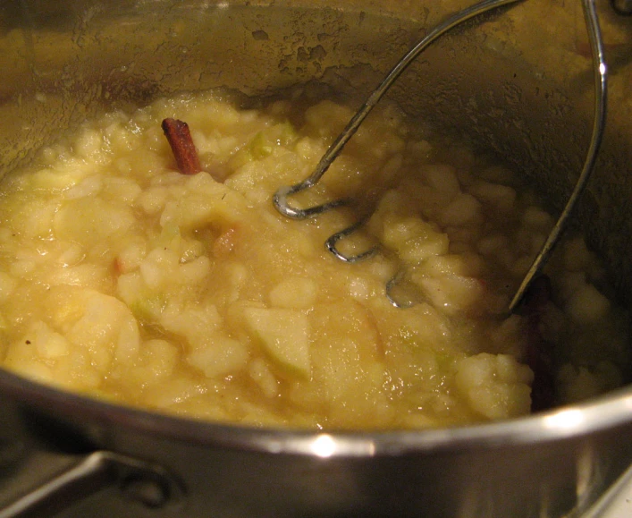 a cooking pot full of food with a whisk and spoon