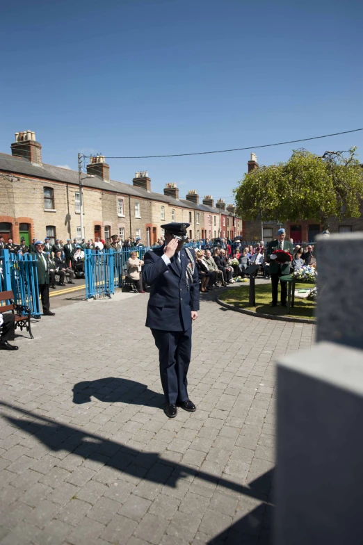 an uniformed guard saluting people while standing outside