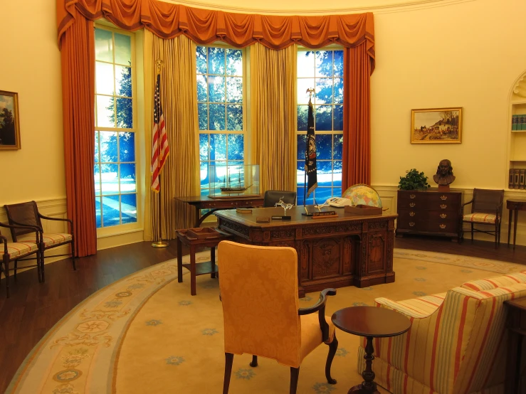 a room with several chairs, and a desk with a american flag on it