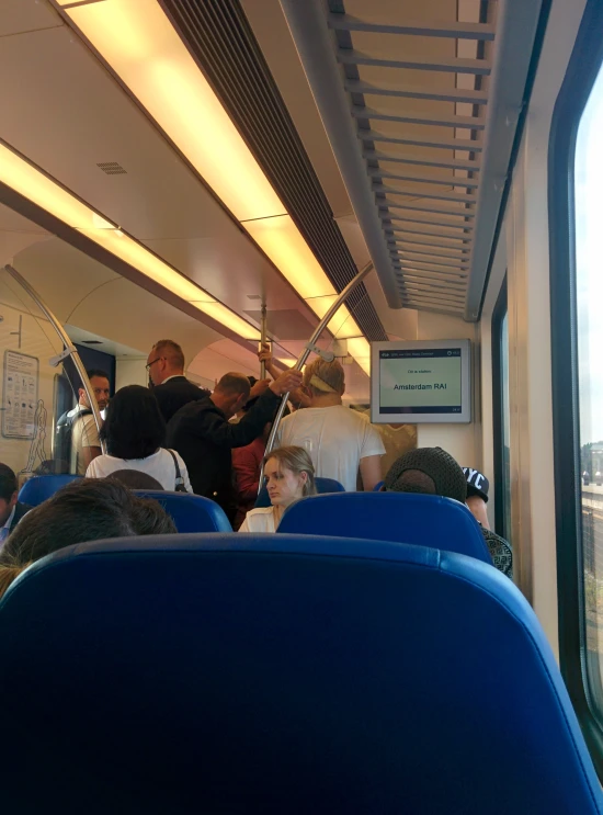 passengers inside train and blue seats, looking out the window