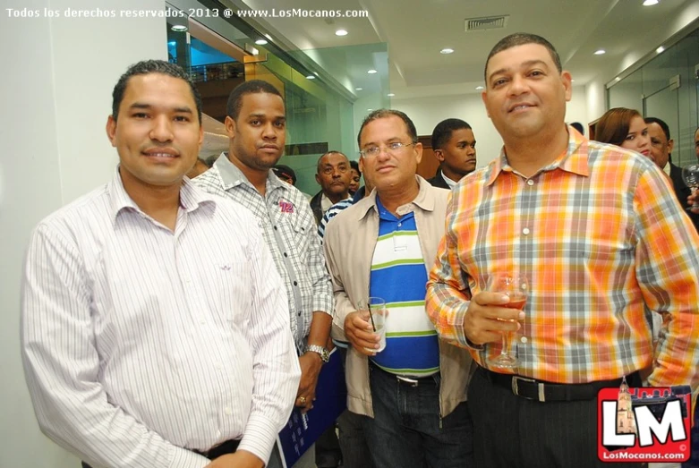 several men stand together, while one man stands on a stool behind them