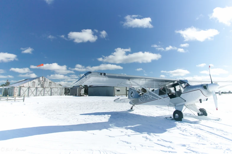 an airplane sitting on a snowy surface in the snow