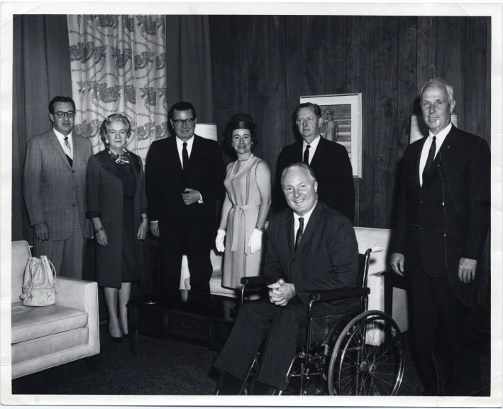 a group of people standing and sitting around a room