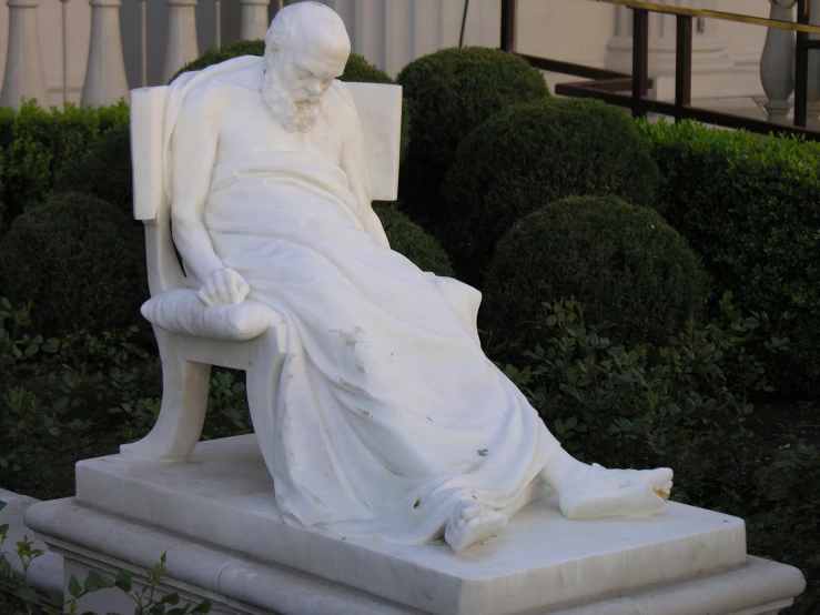 a statue of an old woman sitting on a bench