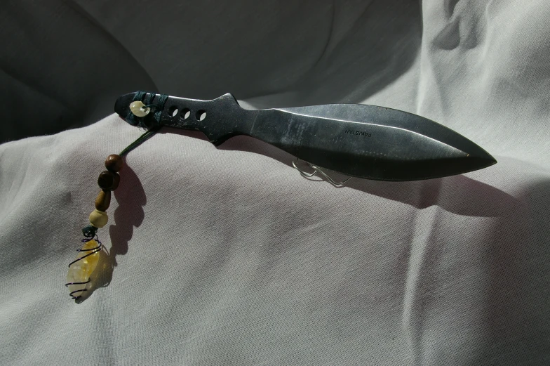 a single blade knife is on top of a white fabric