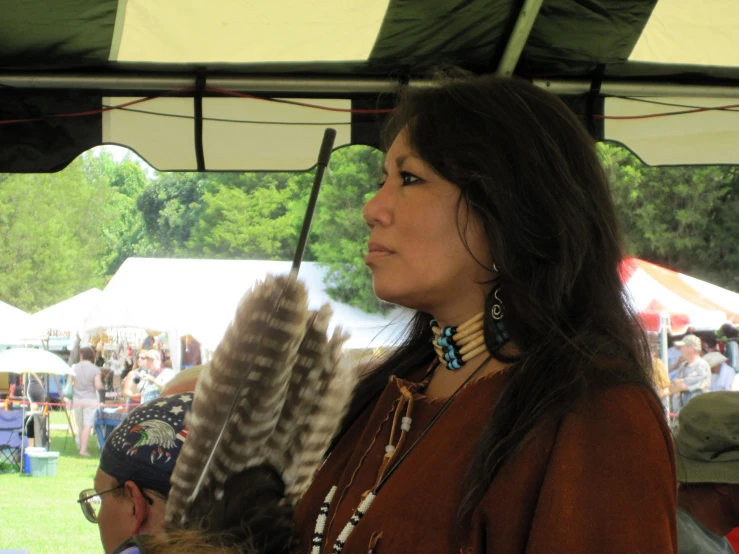 a woman wearing a brown jacket holding a feather