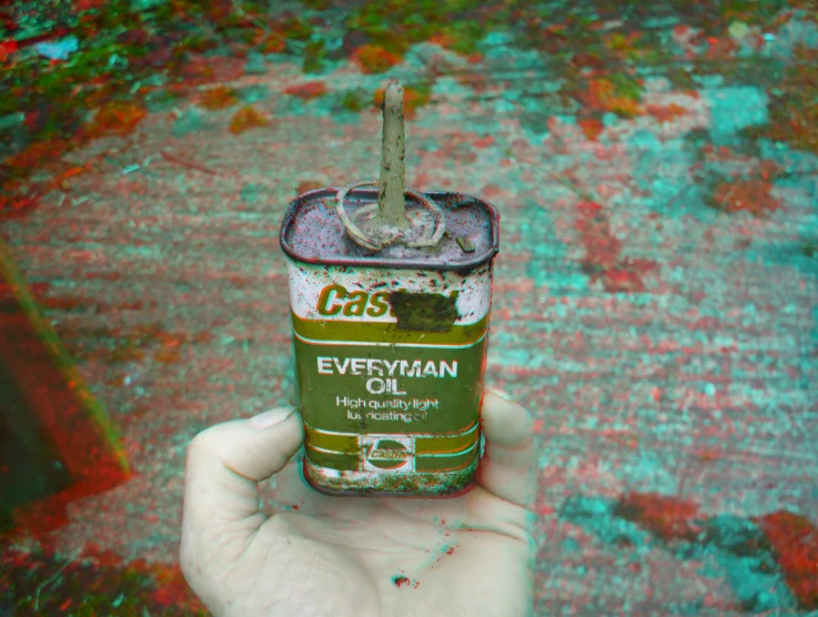 a can of everyman oil in someone's hand
