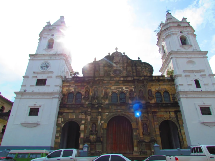 several vans parked in front of a large cathedral